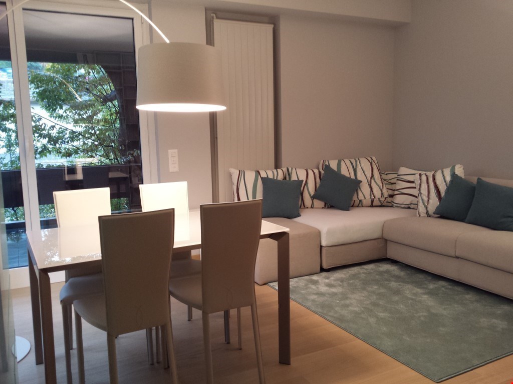 dining area with dining table and chairs, L-shaped couch, rug, carpet, glass door with a balcony, view