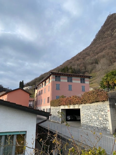2 story building, multiple windows, garage, hilly surroundings