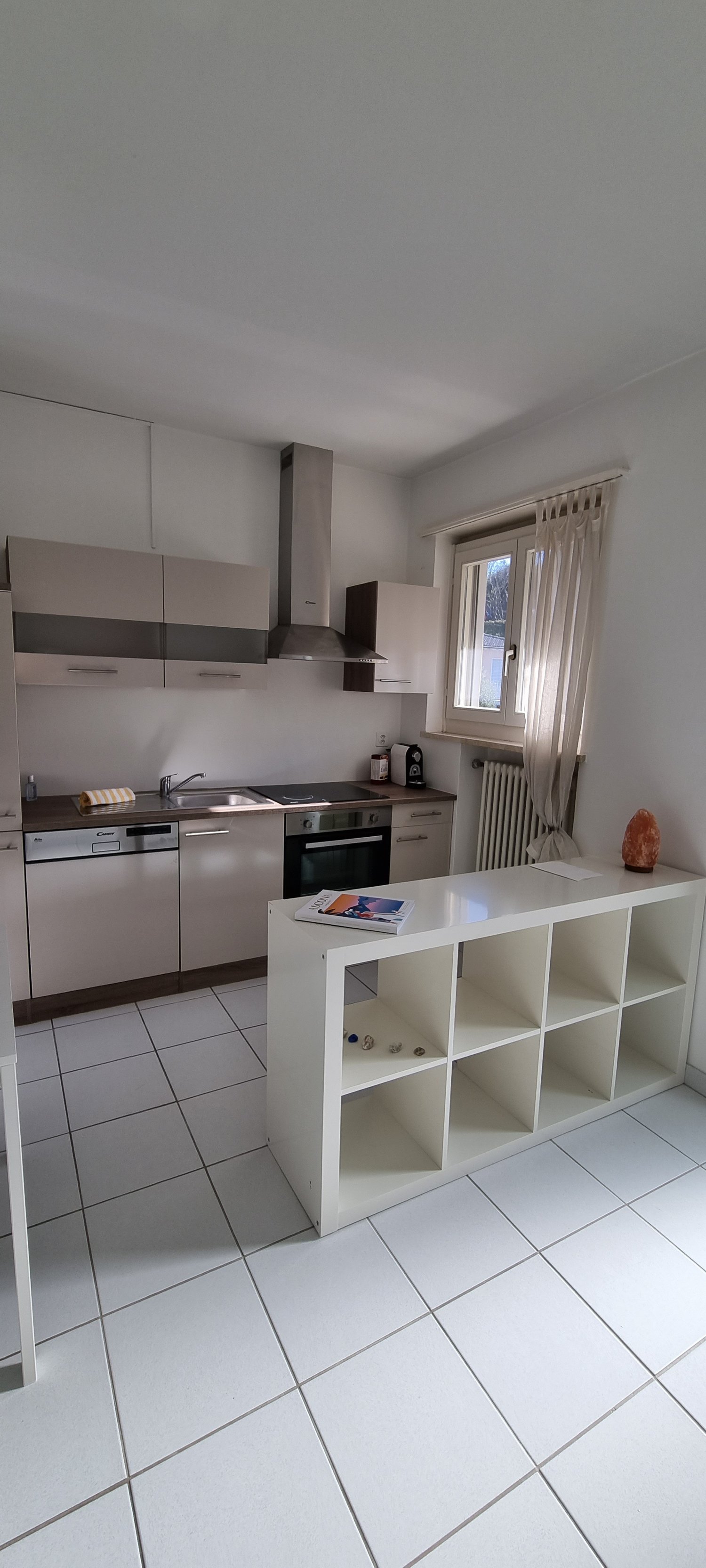 modern kitchen with white cabinetry, dishwasher, washing machine, large tile flooring