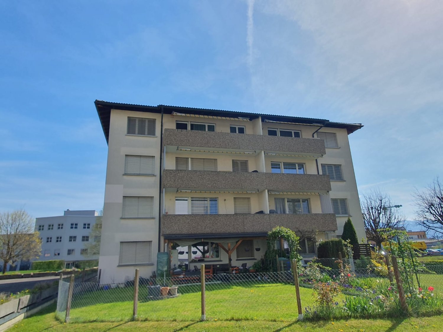 apartment building, beige exterior, multiple balconies, well-manicured lawn