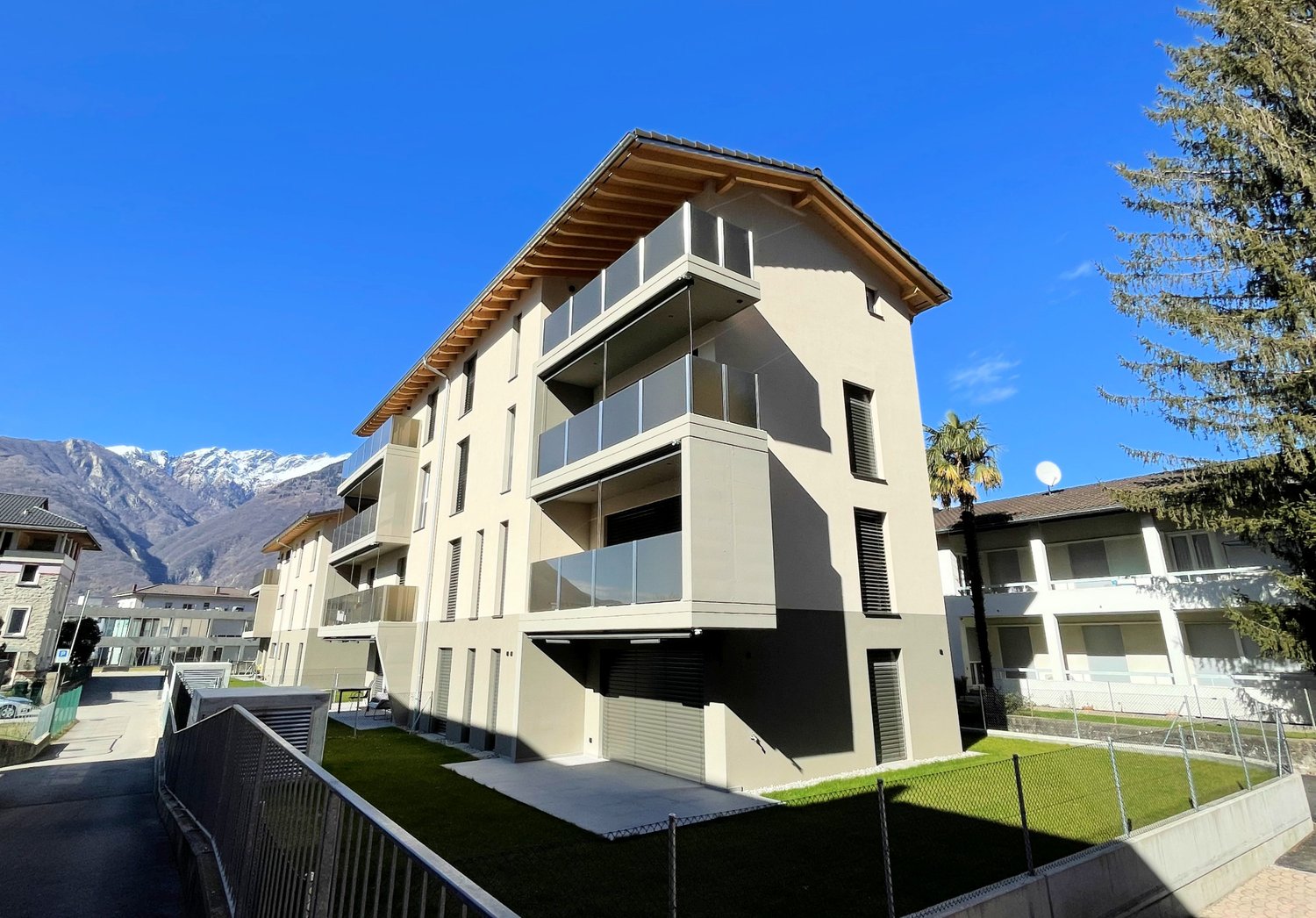 3 story apartment building, modern architecture, balconies, garage, paved driveway