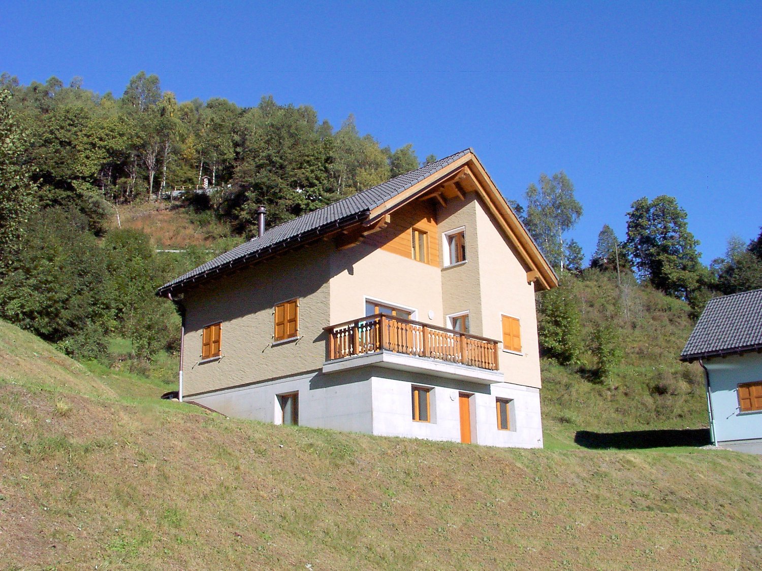 2 story house, beige and wooden exterior, balcony, chimney, raised ground floor