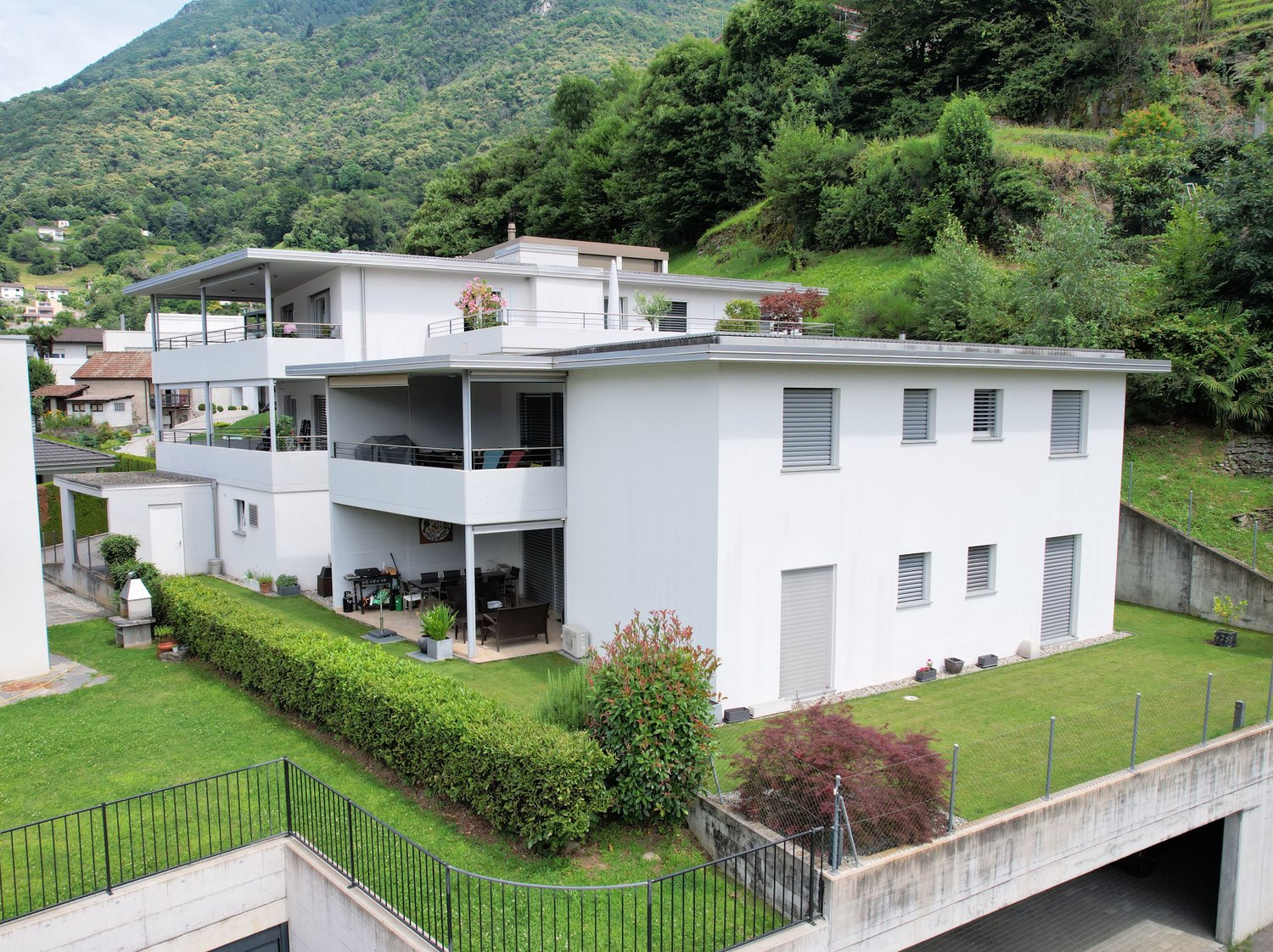 2-story white house, garden, balcony, patio, dining table, potted plants, mountain in the background