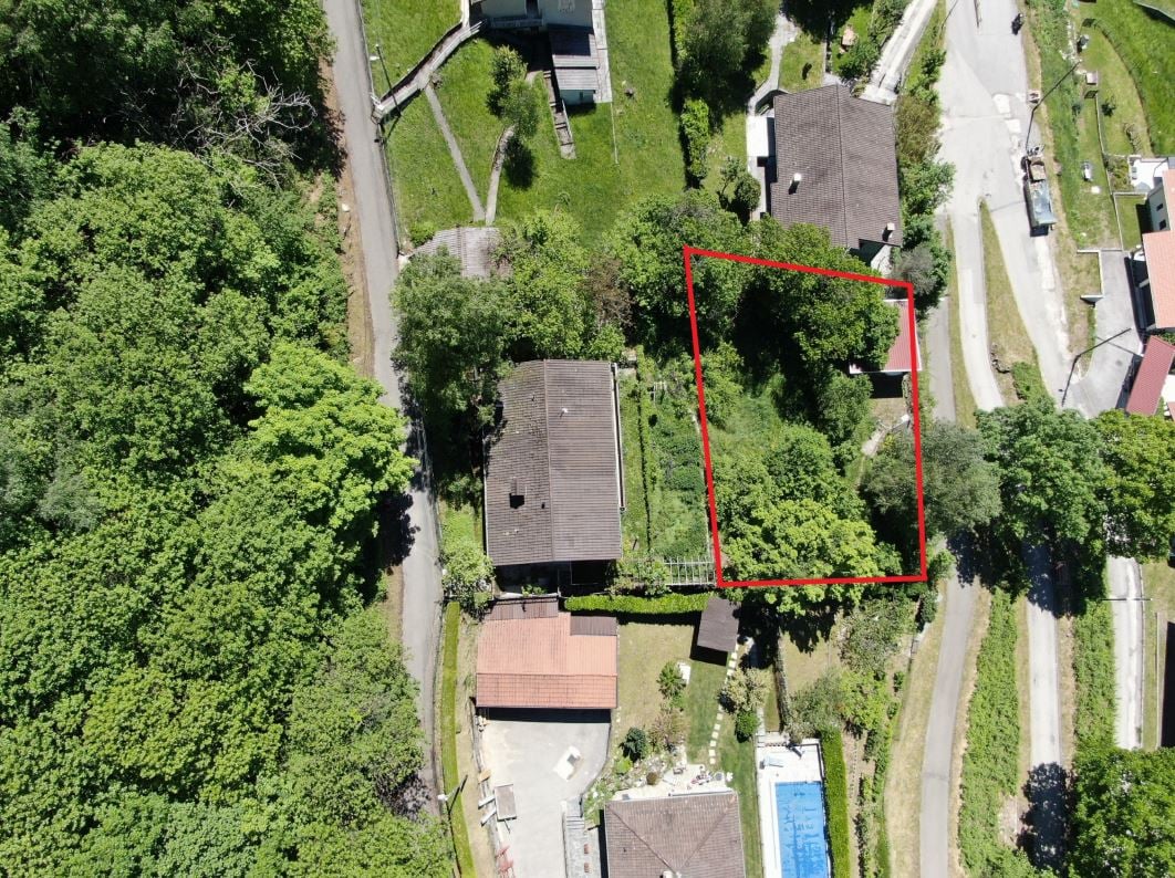 House on elevated plot, surrounded by trees, pool in the corner