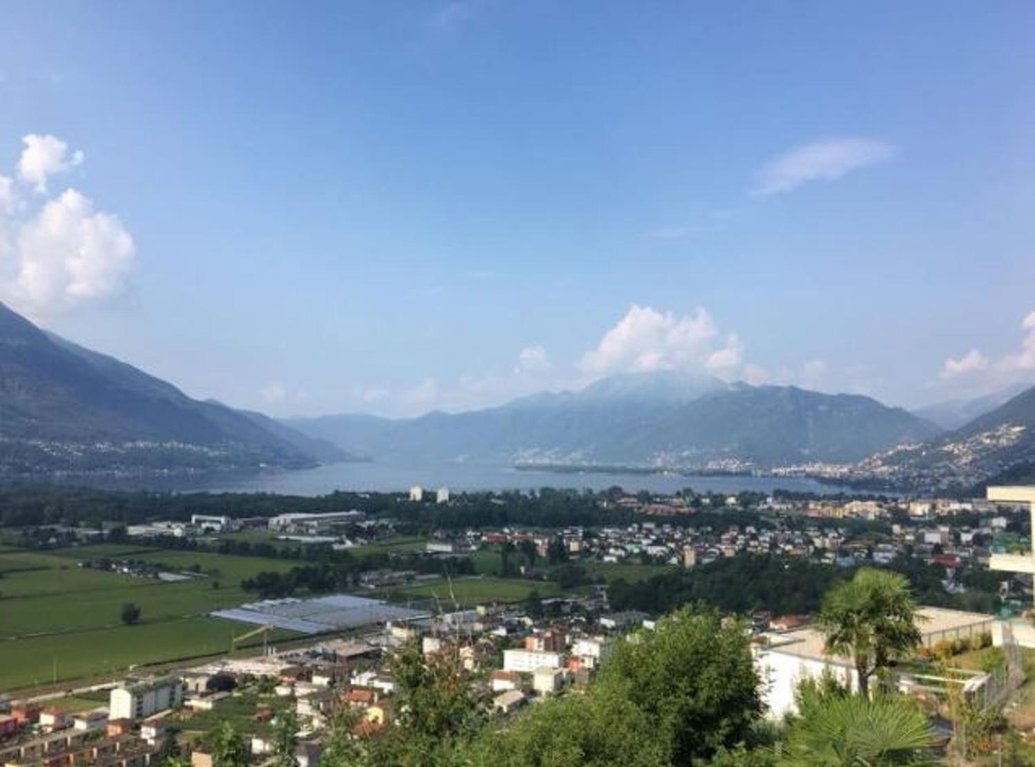 Aerial view of mountains, lake, and city.