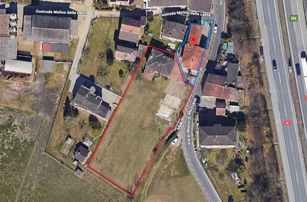 Aerial view of a property showing the layout of surrounding properties, a road, and a plot of land outlined in red, labeled as Contrada Molino della Lenta, with buildings and fields visible.