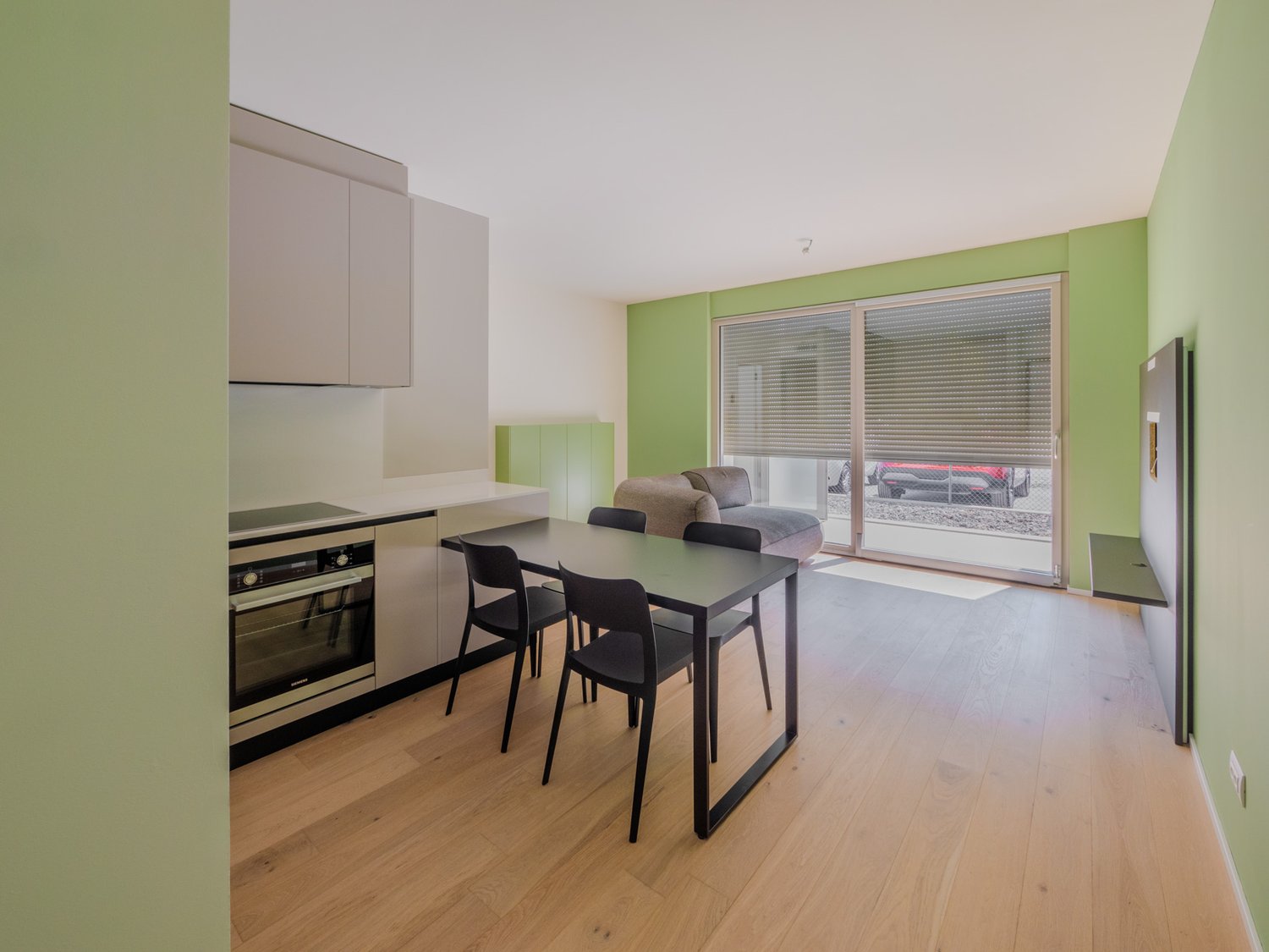 kitchen with dining area, hardwood floors, glass door to balcony, built-in oven, dishwasher, table, chairs