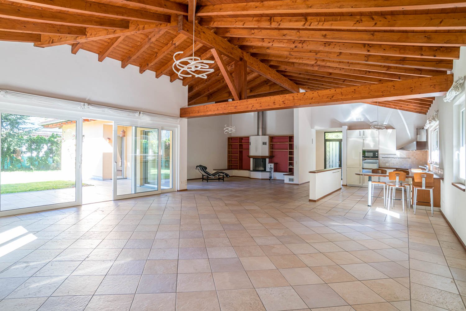 Large open space, wooden ceiling, sliding glass doors leading to a terrace