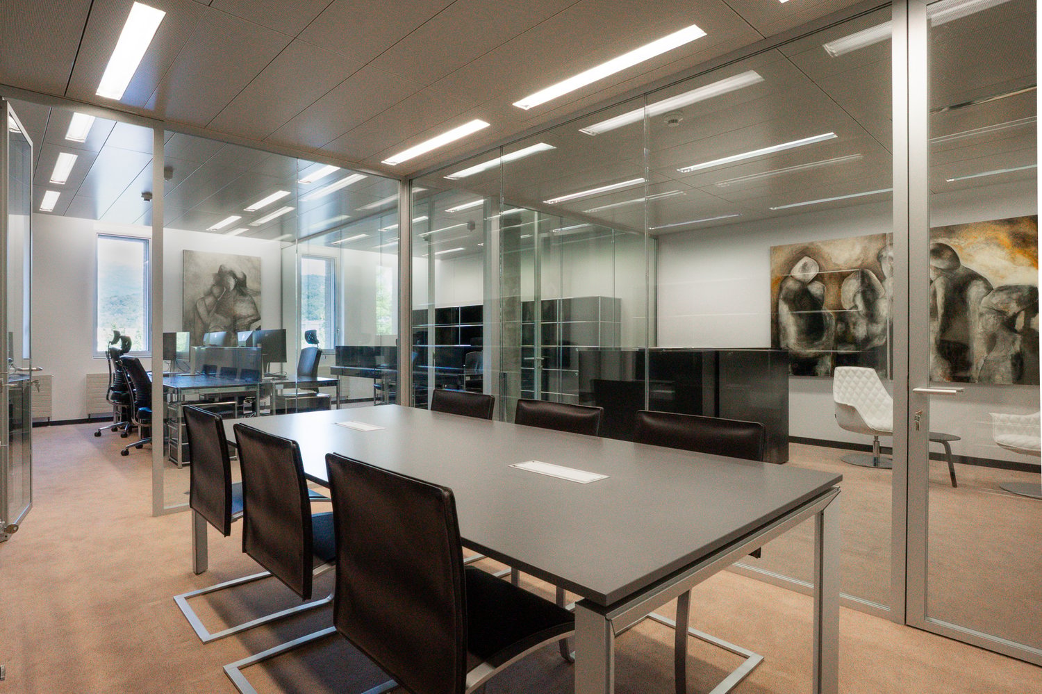 modern office interior with long table, glass walls, chairs, white ceiling, art pieces on the walls