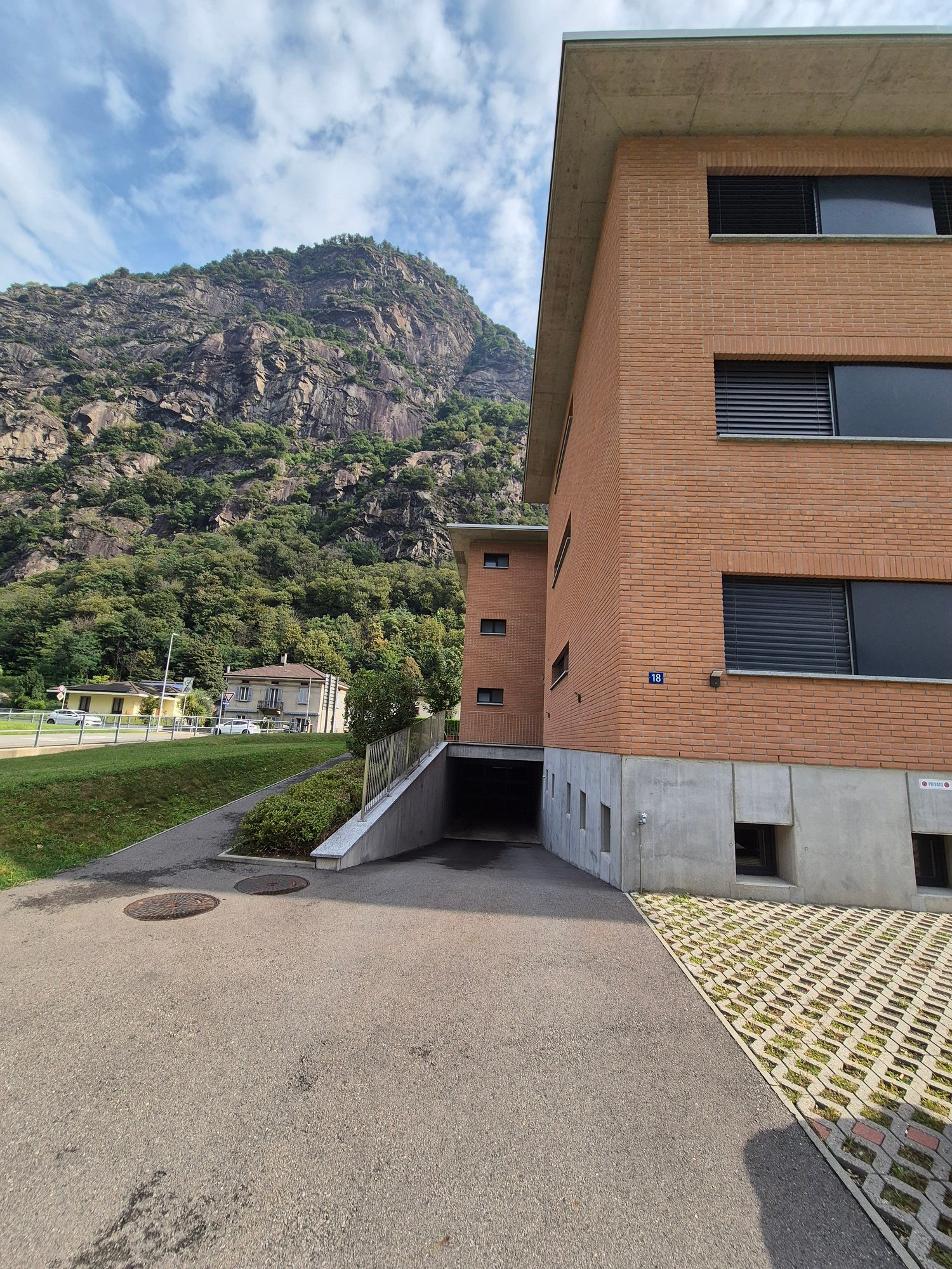 Two-story building with a garage, brick exterior, windows, and a driveway