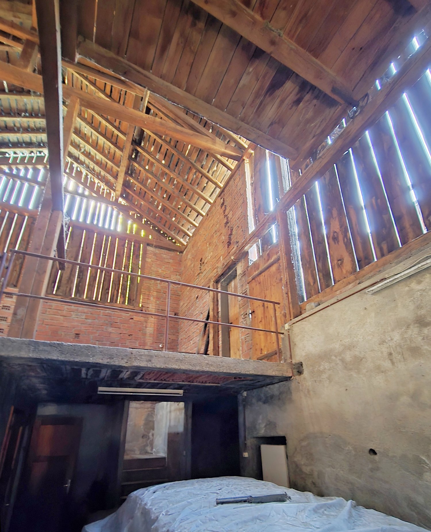 Wooden beam ceiling, exposed brick wall, large wooden balcony