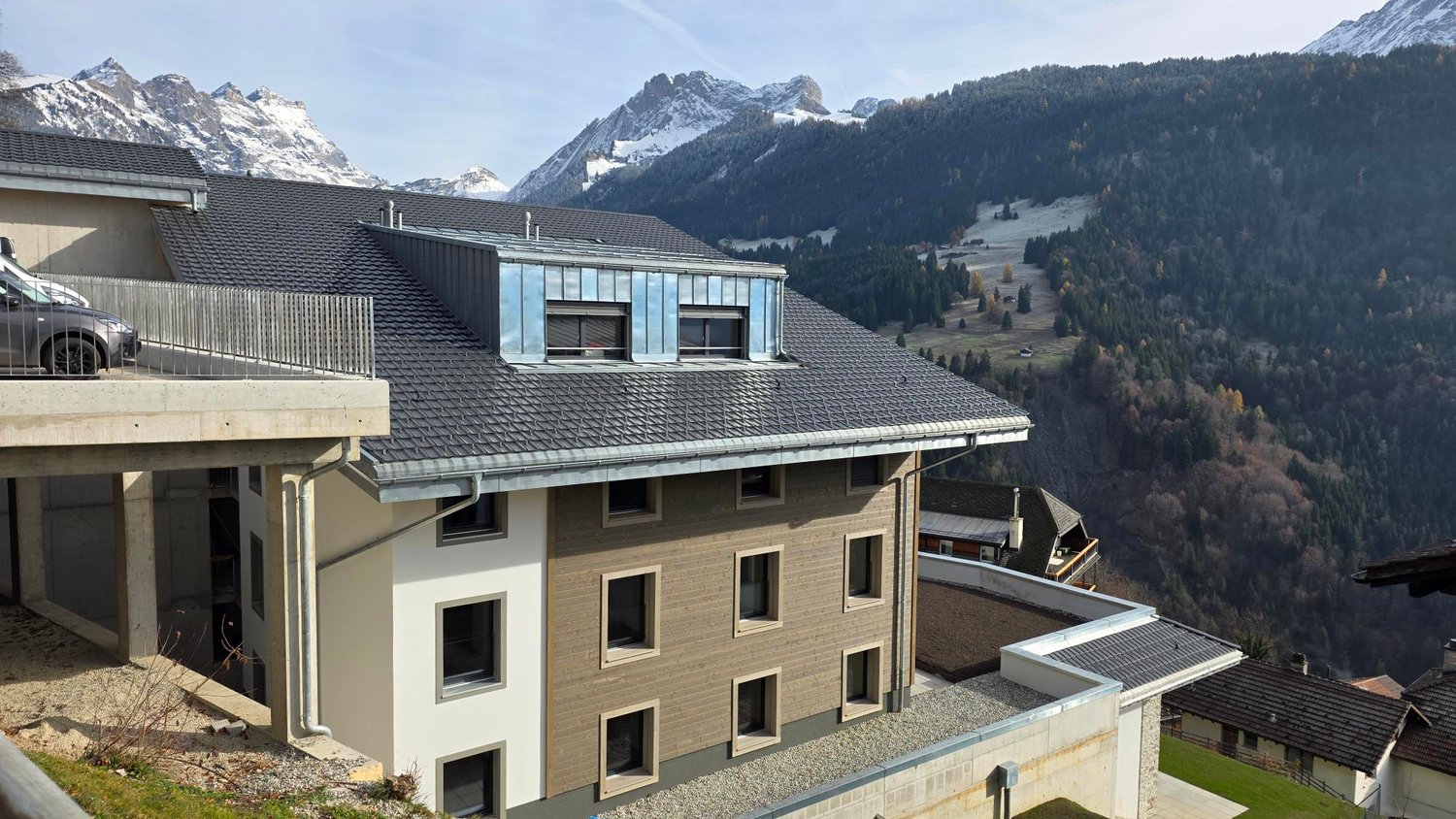 Two-story house, brown and white, multiple windows, parking place