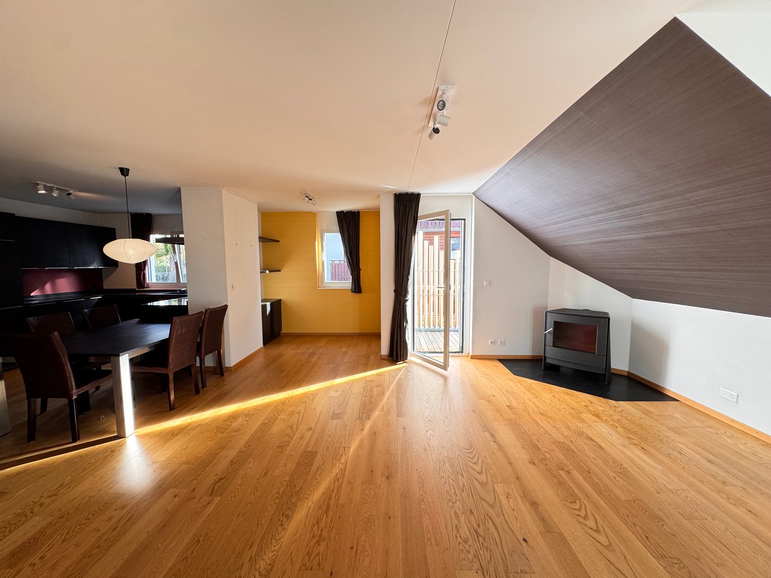 Dining room with hardwood floors, dining table, chairs, yellow walls, fireplace, glass door