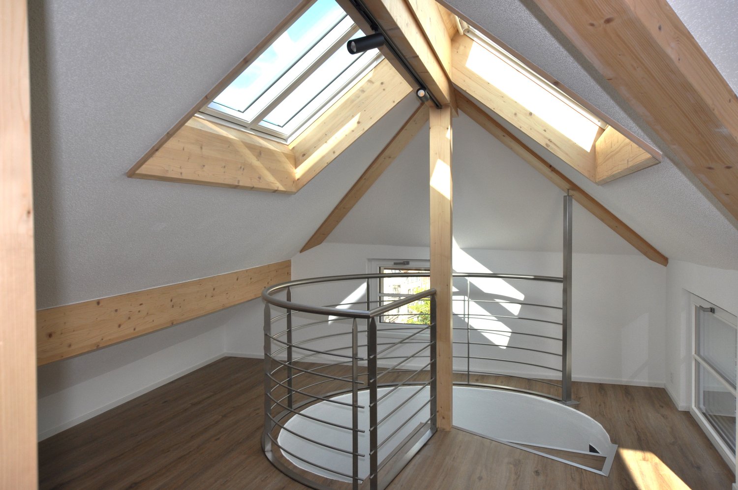 attic room with spiral staircase and skylight