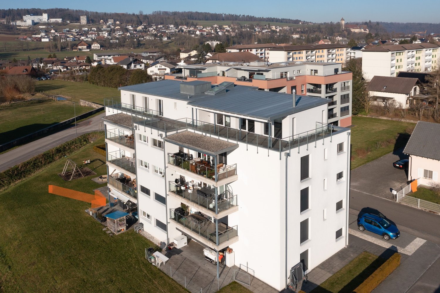 multi-story building with balconies on each floor, located in a suburban area