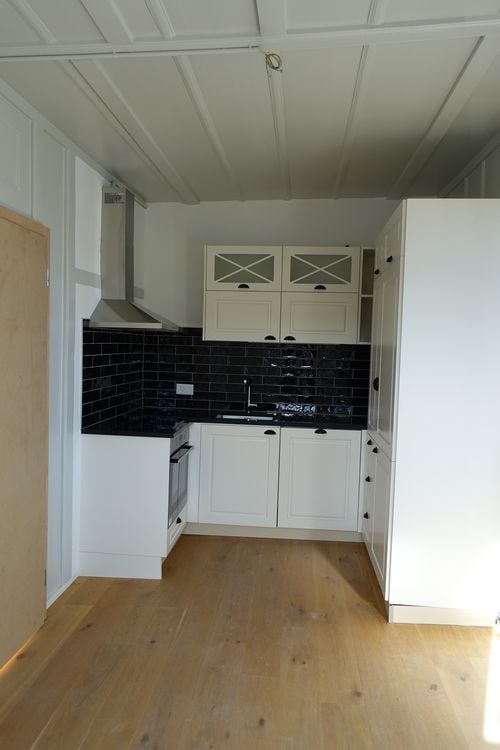 kitchen, white cabinets, black tiles, stove, sink, dishwasher, washing machine