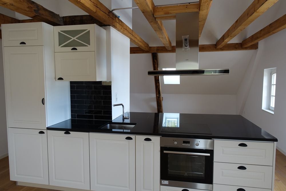 modern kitchen, black countertops, white cabinets, built-in oven, dishwasher, stove top, modern faucet