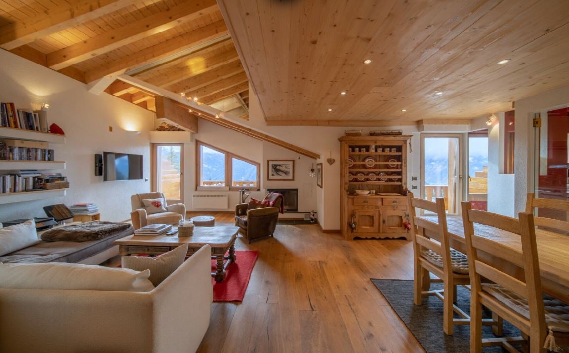 Wooden ceiling, carpet, fireplace, bookshelves, couch, dining table, chairs