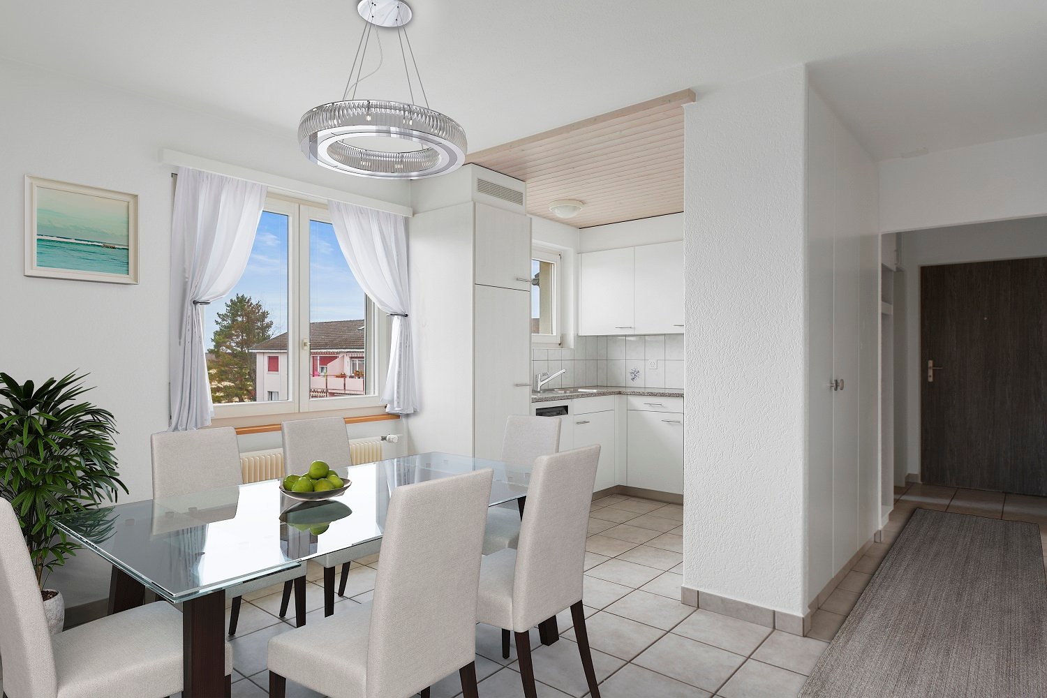Open-concept living area with dining table and chairs, kitchen with white cabinets and appliances, large windows with curtains providing a view of the outdoors, and a modern light fixture above the dining table.