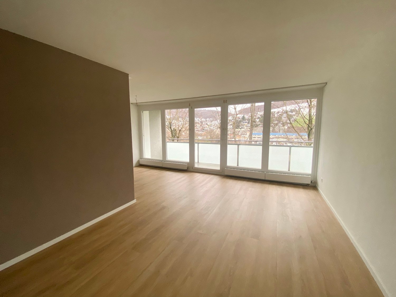 modern room, hardwood floors, large windows, balcony