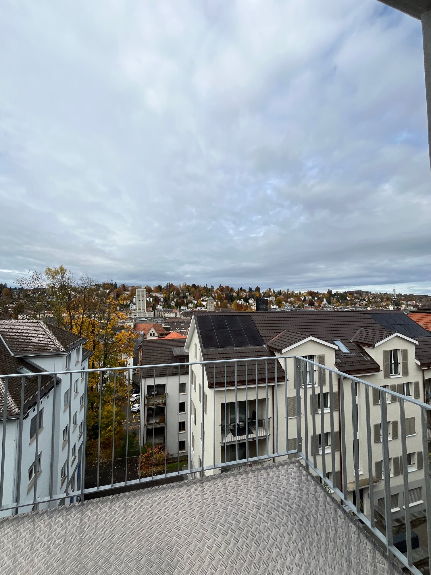 Urban house with a balcony overlooking the city, solar panels on the roof