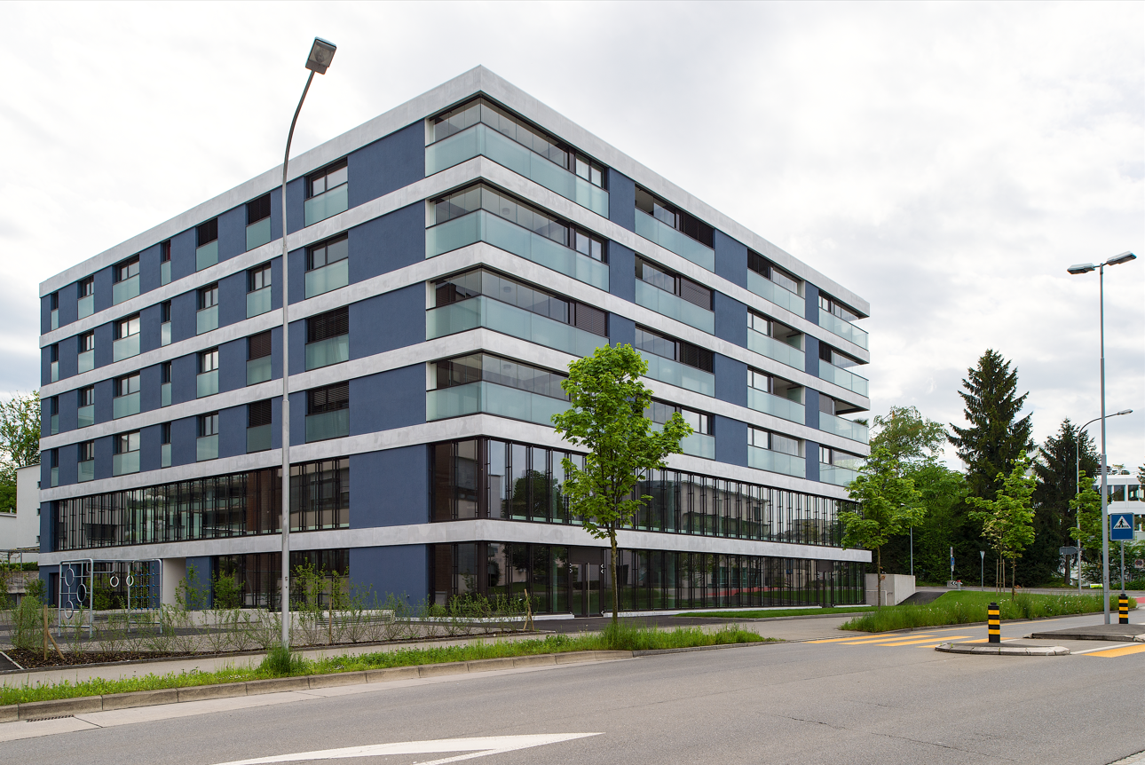 Blue and gray modern building with large glass windows, several floors, exterior wall decorations