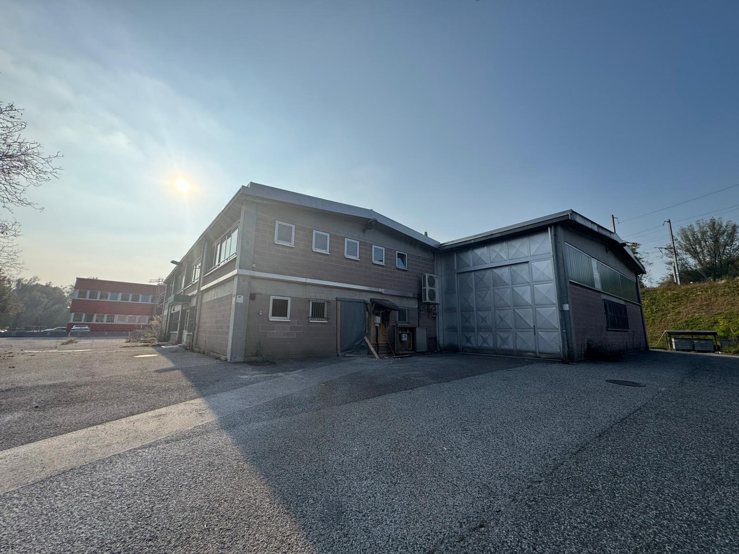two story brick building, large garage, wide asphalt parking area