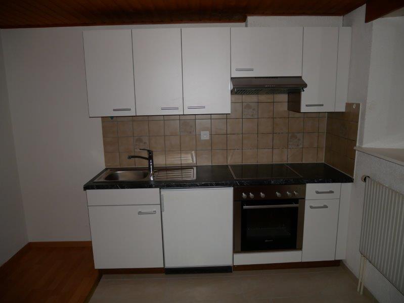 White cabinets, tile backsplash, black countertop, stove, sink, dishwasher