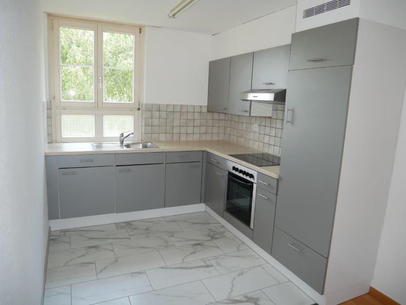 modern fitted kitchen, gray cabinets, marble countertops, sink, stove, oven, extractor hood, natural light