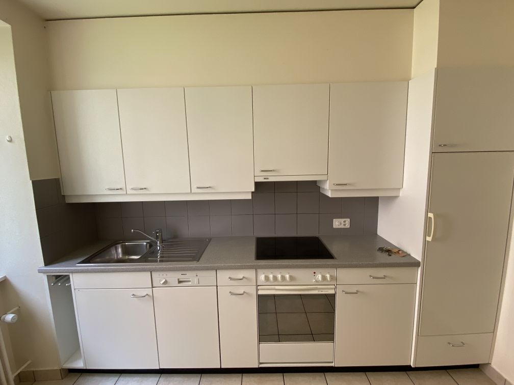modern kitchen with white cabinets, tile floor, stainless steel sink, gas stove, dishwasher, refrigerator