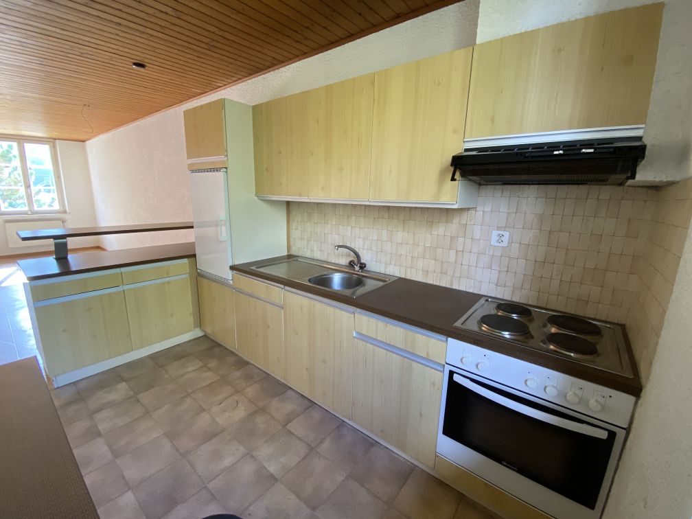 a kitchen with wooden cabinets, tiled floors, countertop, sink, faucet, stove, oven, and exhaust hood