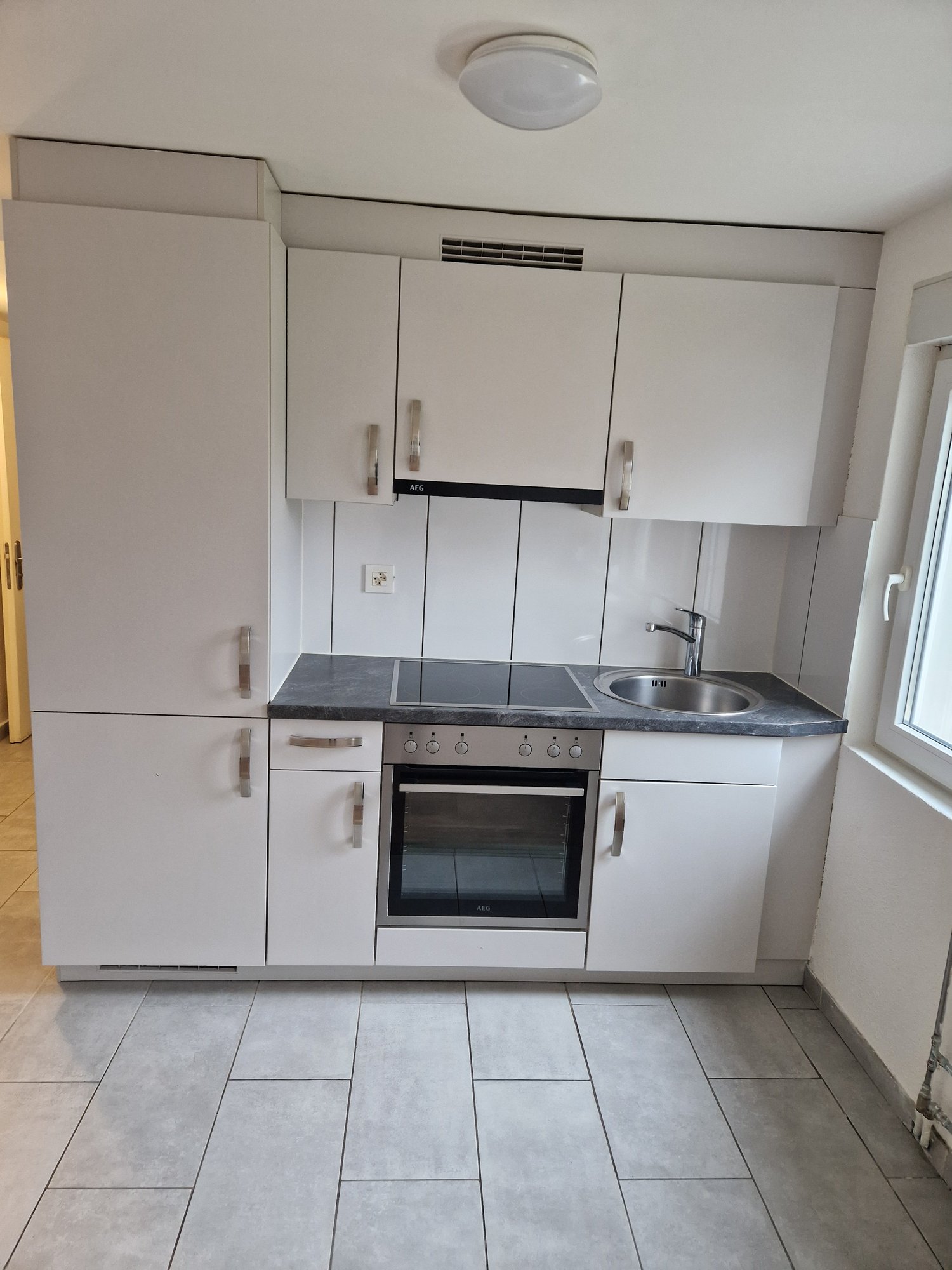 modern white kitchen with gas stove, oven, dishwasher, sink, gray countertop