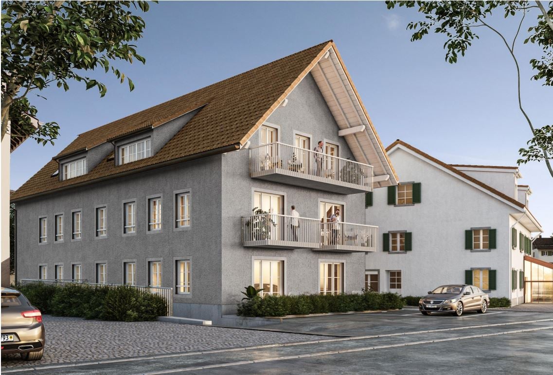 3 story building, grey walls, brown roof, white windows, green shutters, people on balcony, cars parked in front