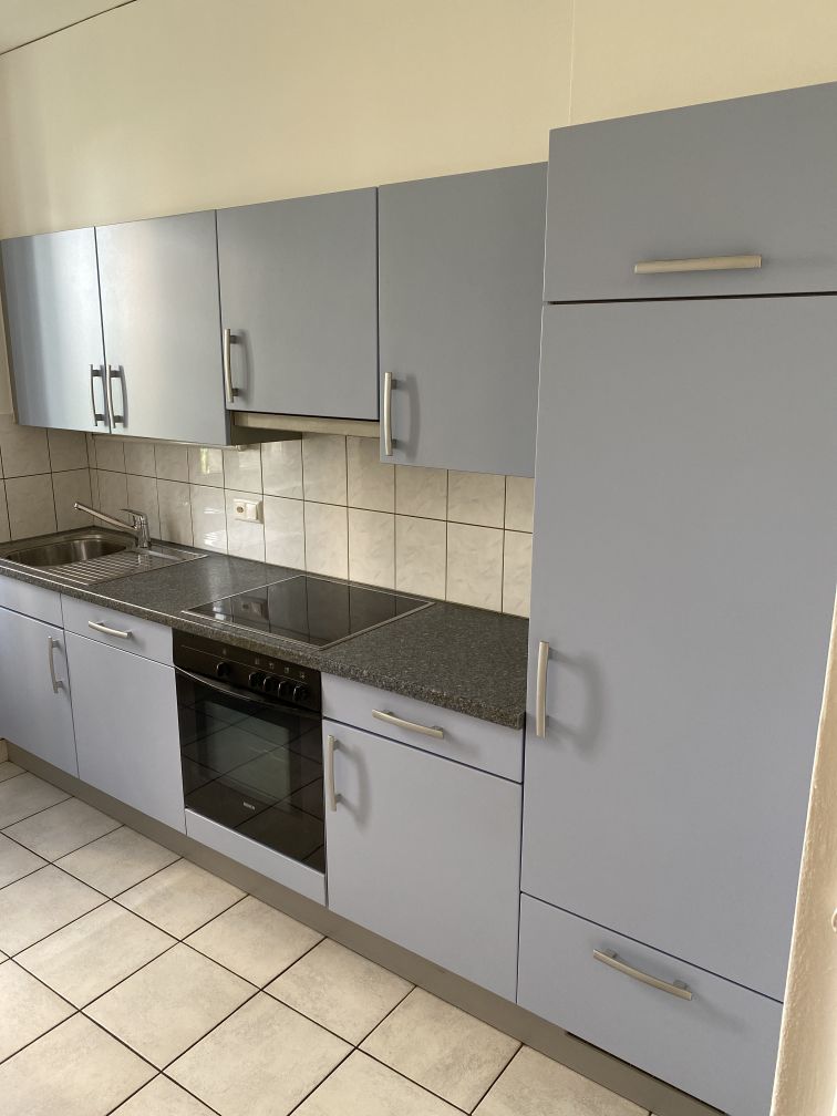 modern fitted kitchen with tiled floor, gas stove, oven, sink, cabinets