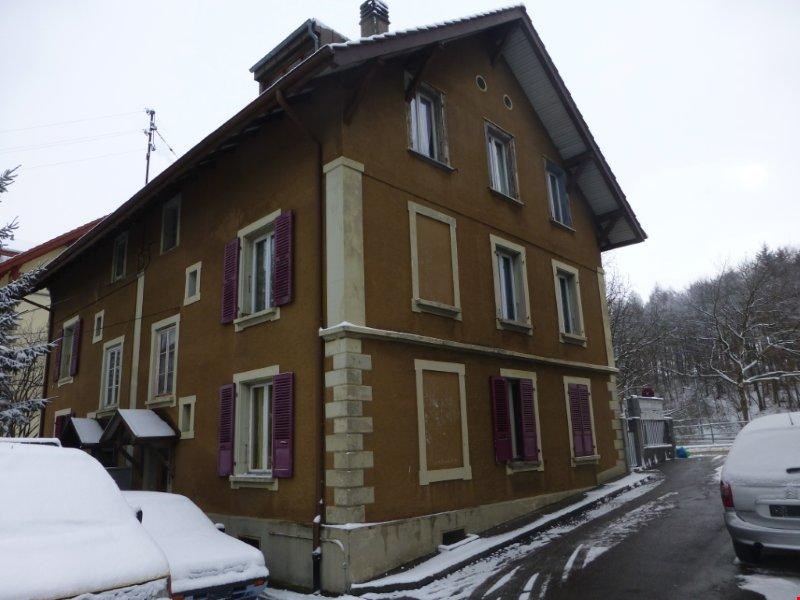 2 story house, brown exterior, white windows, purple shutters, chimney, front yard with snow, 3 cars parked in front