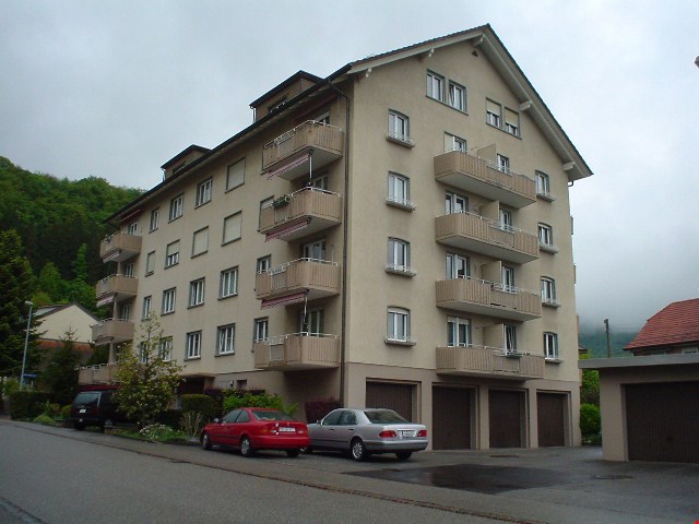 4 story building, beige exterior, multiple balconies, 2 garages