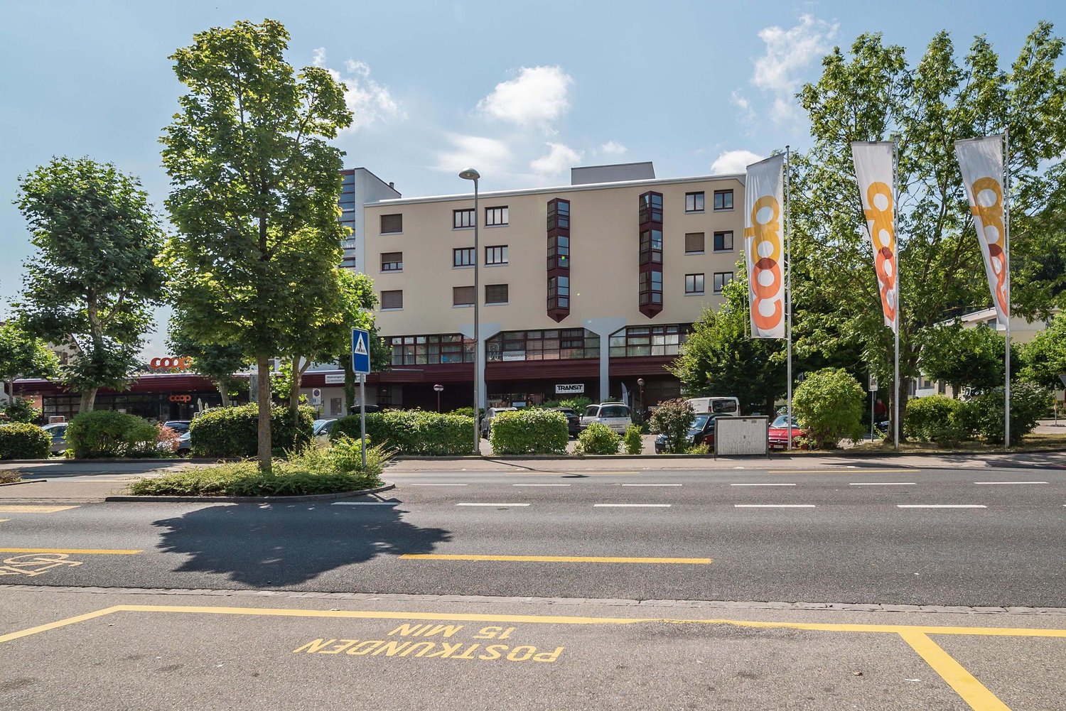 3 story building, glass windows, metal railings, outdoor seating area, parked cars, street light