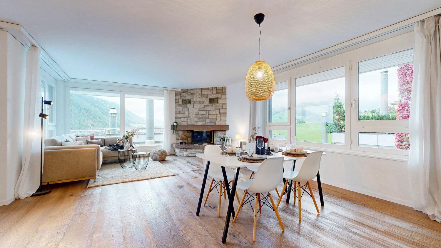 Dining table with chairs, fireplace, large windows, couch, rug, pendant light