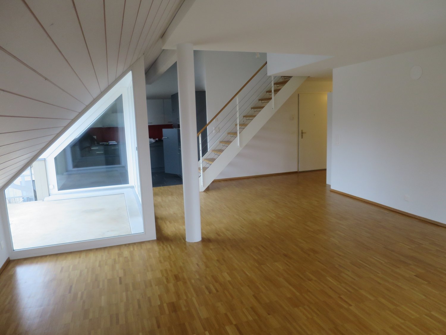 empty room, wooden floor, white walls, large glass window, staircase, open area