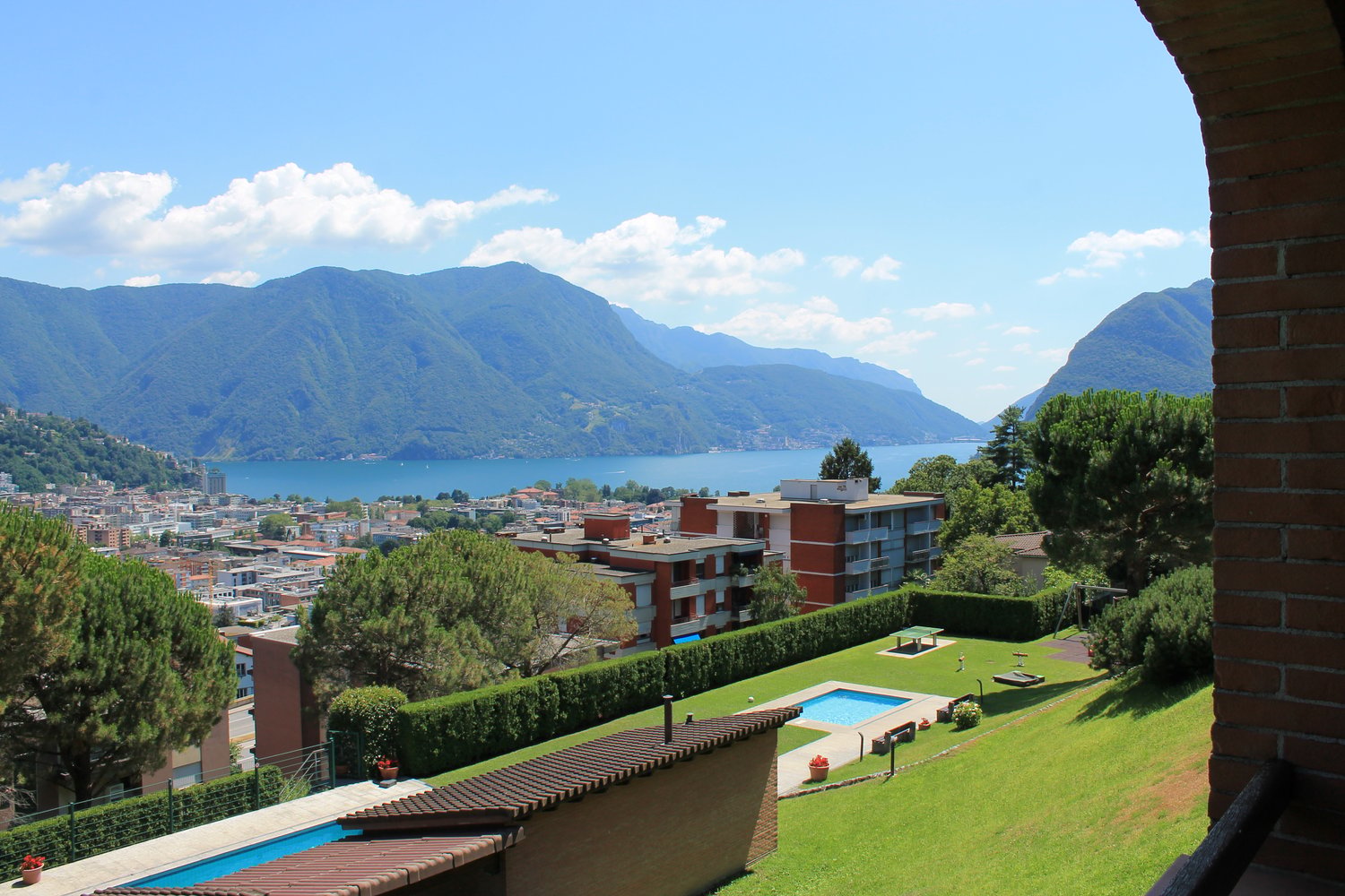 Building with a view of the city and mountains, swimming pool, and a lake
