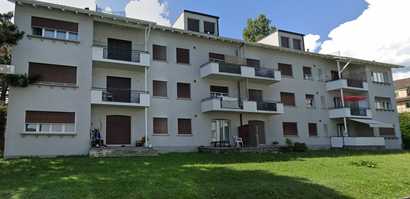 3 story apartment, balconies, plants, green lawn