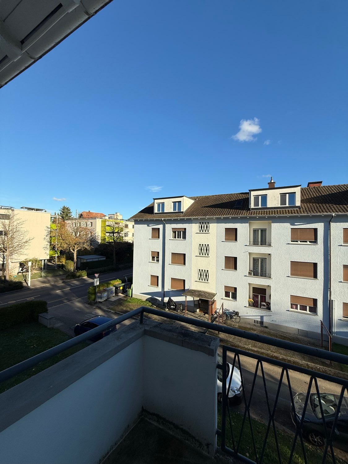 outside of a modern apartment building with balcony, on a sunny day