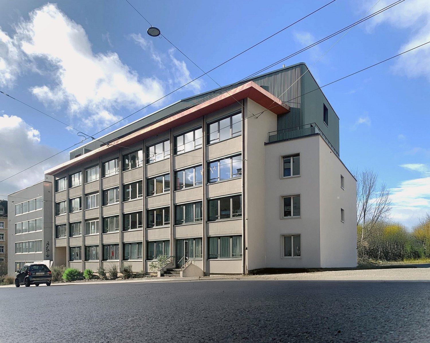 Multi-story building, multiple windows, green roofing, modern design, residential complex