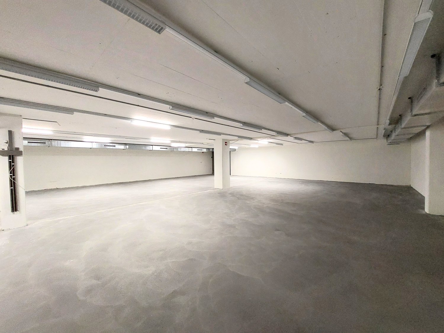 empty room, white walls, gray floor, fluorescent lights on ceiling