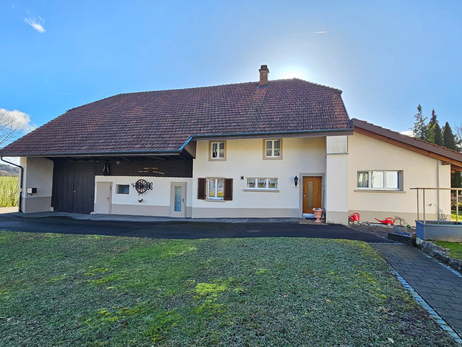 House with brown roof, two story, brown garage, paved driveway, green lawn