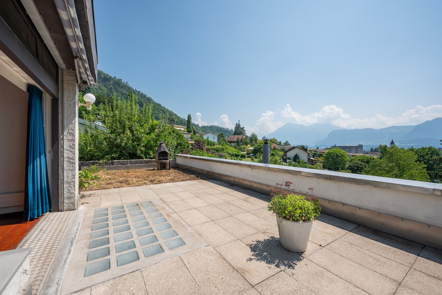 tiled floor, potted plant, wall, railing, mountain view