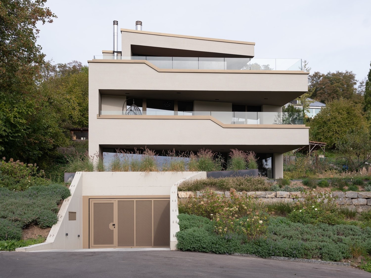 Modern house, white concrete, glass railings, recessed ground floor, garage entrance