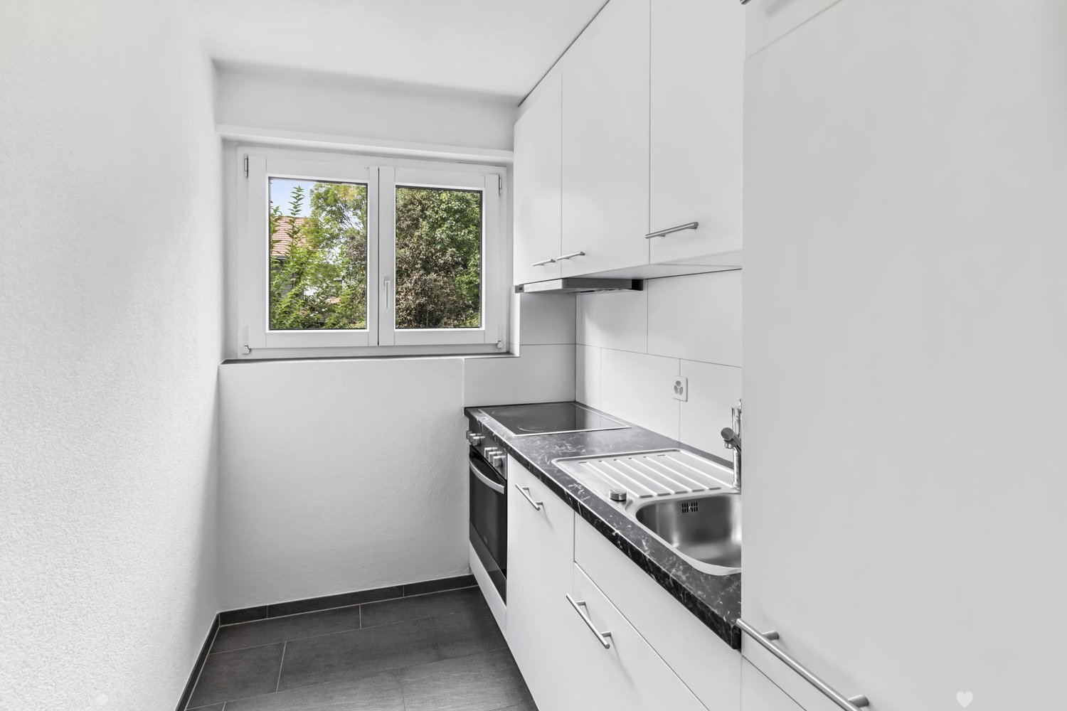 modern kitchen with white cabinets, black countertops, stainless steel sink, electric stove, oven, dishwasher, window