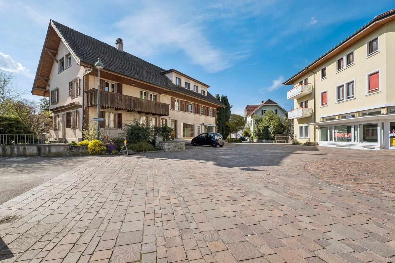 3 story house, brick facade, wooden balcony, brick driveway
