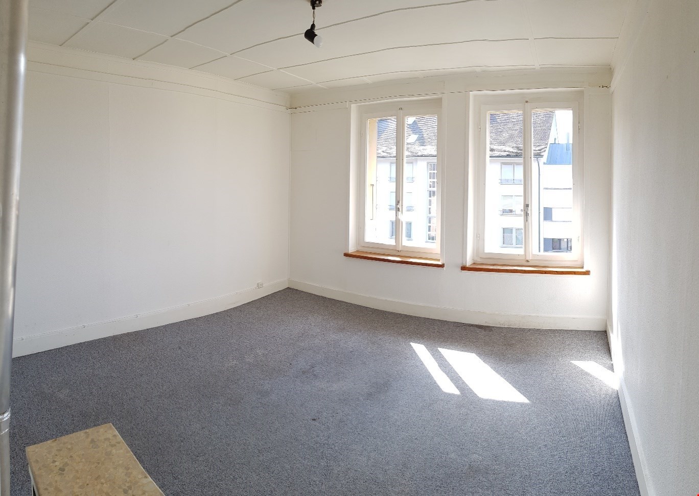 empty room, 2 windows, carpeted floor, white walls, light fixture